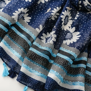 Detail of navy blue bohemian scarf with daisy floral print and stylish fringe tassels
