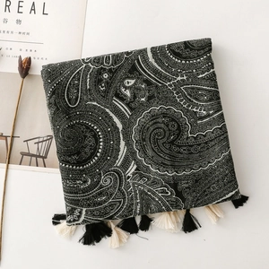 Detailed view of bohemian paisley scarf with tassels and artistic lifestyle props