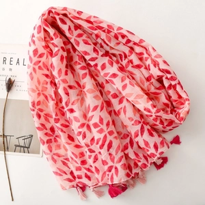 Detail of pink scarf with red geometric leaf prints and delicate two-tone tassels