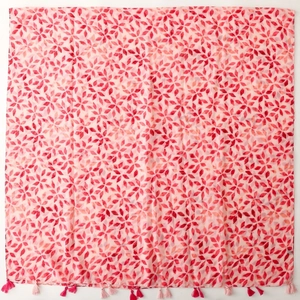 Elegant red square scarf with geometric floral print and hanging tassels on light background