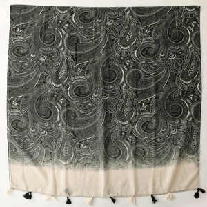 Close-up of bohemian paisley scarf detail with delicate black and white tassels