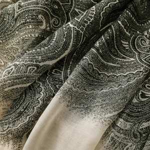 Macro detail of Bohemian paisley pattern fabric showing fine texture and tassels