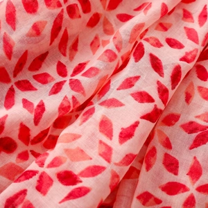 Detail of red geometric crystal print on soft pink breathable scarf fabric with fringe