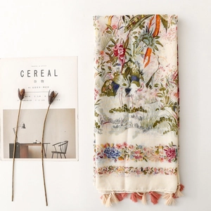 Bohemian floral scarf with crane prints and tassels, displayed on a minimalist white desk