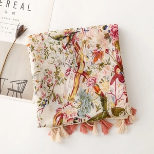 Detail of floral and bird print shawl with elegant pink and cream fringe tassels