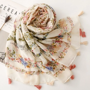 Detail of bohemian floral scarf with soft tassels and vintage botanical patterns