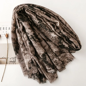 Close-up of abstract marble pattern scarf with frayed edges and lightweight fabric