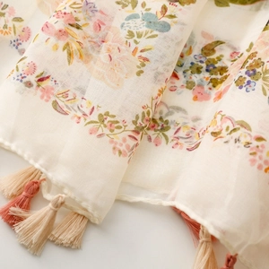 Detail showing soft floral print scarf with elegant two-tone tassel fringe accents