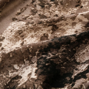 Macro detail of ethnic style scarf showing brown and black mottled texture on soft fabric