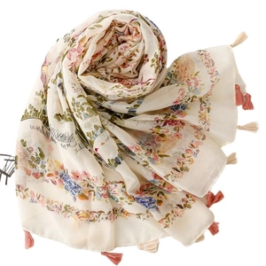 Bohemian floral scarf with botanical prints and fringe tassels on a soft cream background