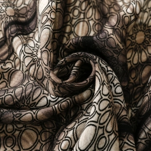 Close-up of geometric mandala print fabric with soft knitted texture in earth tones