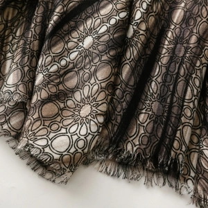 Detail of vintage geometric mandala print scarf with soft fringe edges and fabric texture