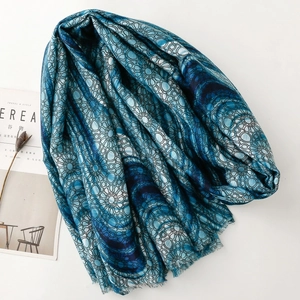 Detailed close-up of blue geometric pattern scarf with frayed edges and Cereal magazine