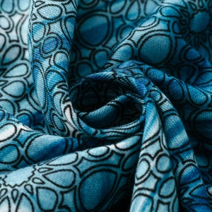 Detail of blue geometric mandala print on soft fabric with elegant draped texture