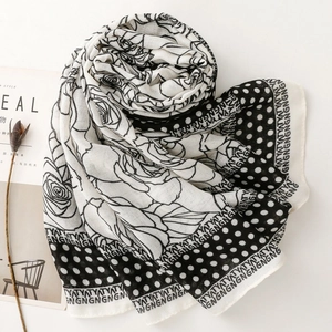 Macro detail of black and white silk scarf with large rose floral and polka dot patterns
