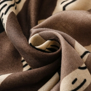 Macro detail of soft printed fabric showing elegant brown patterns and knit texture