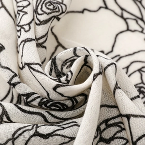 Detailed macro texture of a cream scarf with black rose floral line art patterns