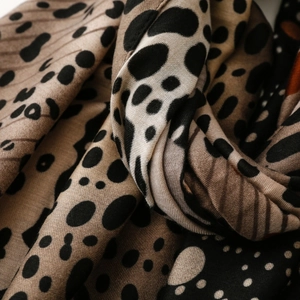 Macro detail of scarf showing leopard print, polka dots, and twill fabric texture