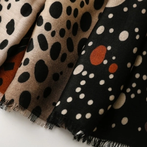 Macro detail of soft polka dot scarf with fine fringe edges and folded texture