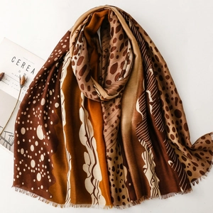 Leopard print winter scarf with tassels and polka dot pattern in deep brown tones