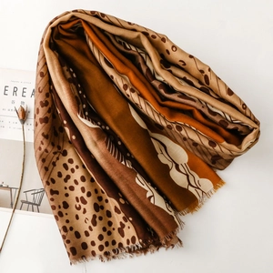 Detail of soft leopard dot print scarf with fringed edges and warm autumn earth tones