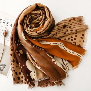 Modern abstract print scarf with geometric patterns and fringe tassels in warm tones