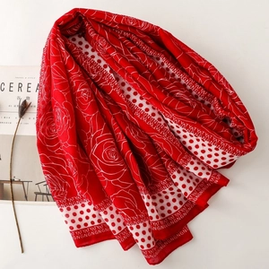 Detail of red floral and polka dot scarf laid neatly next to a lifestyle magazine