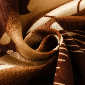Macro shot of abstract leaf print scarf with soft textures and spiral pleated details