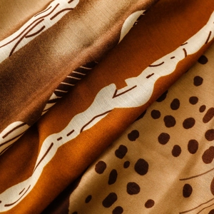 Close-up of bohemian printed scarf fabric with earth tone waves and soft textures