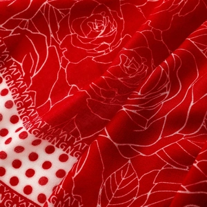 Close-up of red floral chiffon scarf fabric with white roses and polka dot printing