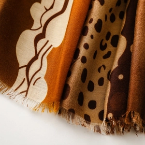 Close-up of leopard and wave print scarves showing soft frayed edges and fabric texture
