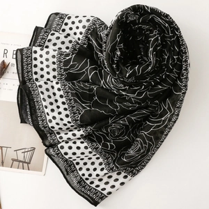 Detailed flat lay of floral polka dot scarf with stylish monochrome rose patterns