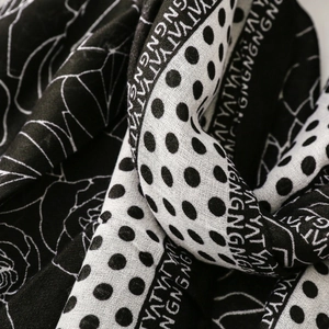 Detail of floral and polka dot print on soft black and white scarf fabric