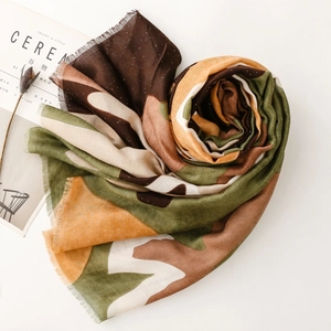 Détail de l'écharpe en coton lin camouflage avec touches dorées et bords effilochés
