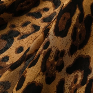 Close-up of leopard print scarf fabric showing light weave texture and brown tones