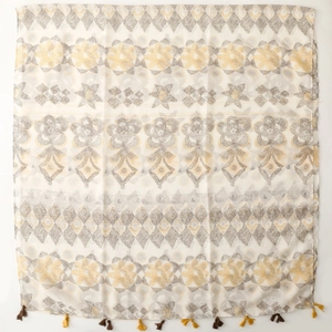 Ethnic bohemian scarf with geometric floral patterns and tassels on beige fabric