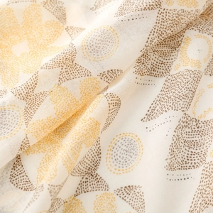 Detailed macro view of bohemian floral print fabric with tassels and soft linen texture