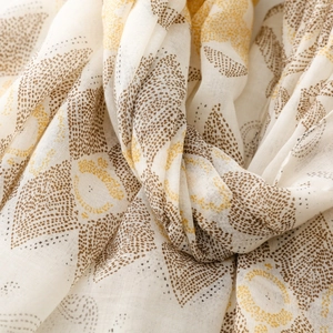 Macro detail of bohemian geometric floral print on lightweight cream textured fabric scarf