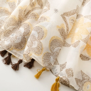 Detail of bohemian floral scarf featuring ethnic patterns and colorful fringe tassels
