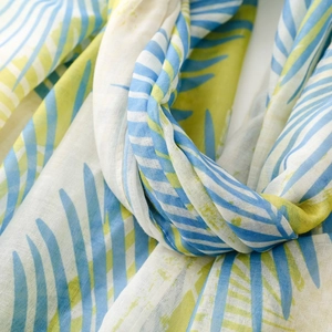 Détail de l'écharpe à imprimé feuilles de palmier bleues et vert citron en lin