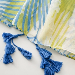 Détail d'écharpe à rayures vert citron et bleu avec des pompons à franges bleu foncé