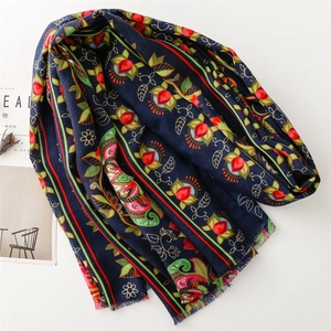 Detail of dark blue ethnic shawl with intricate floral embroidery and tassel fringe