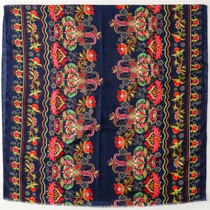Ethnic navy blue scarf with colorful paisley patterns and fringed edges on white background
