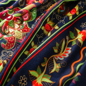 Macro detail of navy blue herringbone scarf featuring vibrant floral prints and weave texture