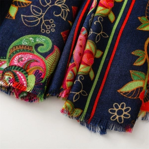 Close-up of navy blue scarf with retro floral paisley patterns and fringed edges
