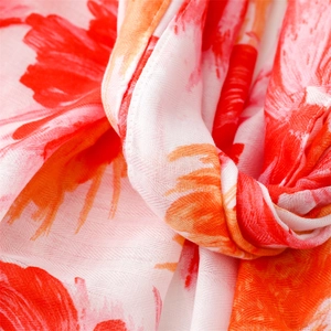 Detailed view of herringbone weave scarf featuring vibrant red tropical floral patterns