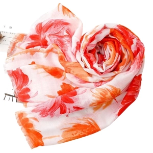 Chic cotton-linen feel scarf with red floral print and fringe details on white backdrop