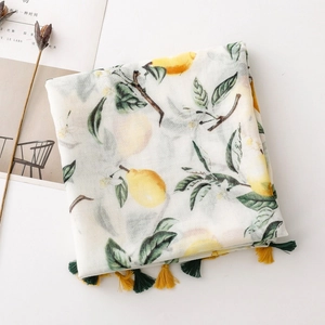 Detail of bali yarn scarf featuring yellow lemon prints and colorful tassel edges
