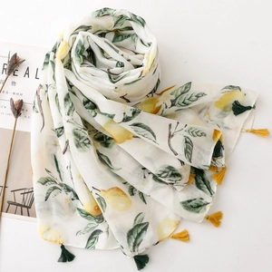 Detail of thin scarf with yellow lemon print and matching green tassels on edges
