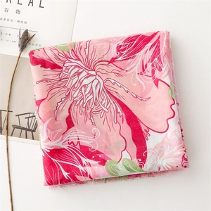 Detail of pink floral cotton scarf with realistic flower patterns and frayed edges